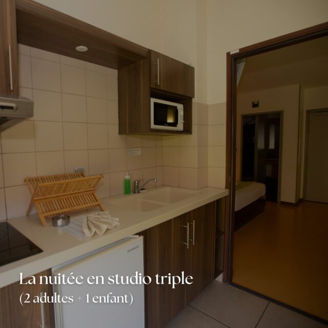 Kitchenette équipée d'un studio triple d'hôtel pour 2 adultes et 1 enfant, avec micro-ondes et réfrigérateur.